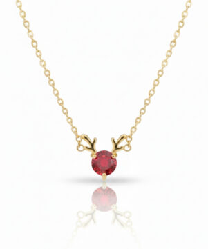 Full view of a gold reindeer antler necklace with a vibrant red cubic zirconia stone, presented on a pure white background with a subtle reflection.