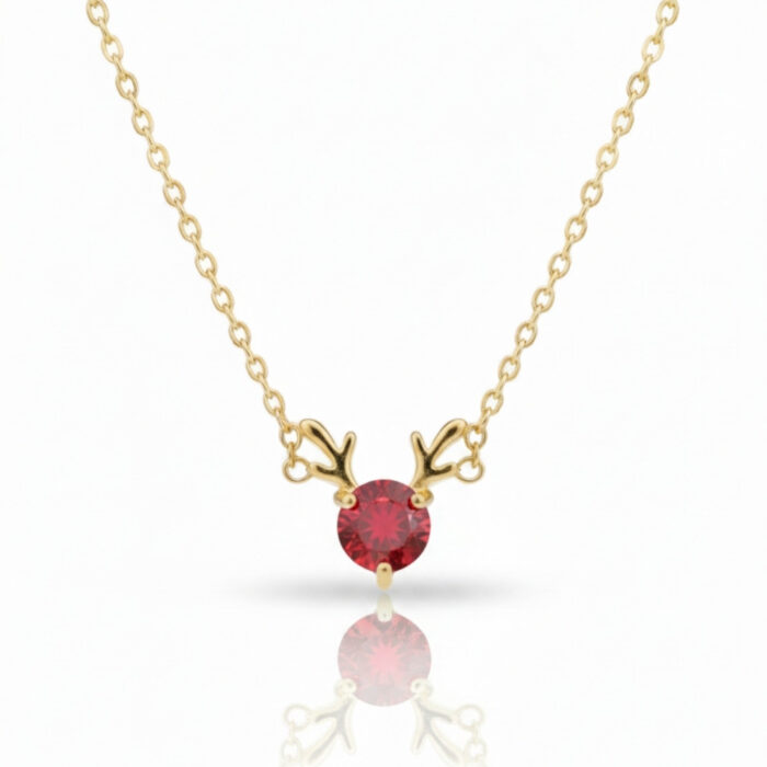 Full view of a gold reindeer antler necklace with a vibrant red cubic zirconia stone, presented on a pure white background with a subtle reflection.