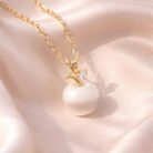 Apple-Shaped Pearl Bead Pendant Necklace on fabric